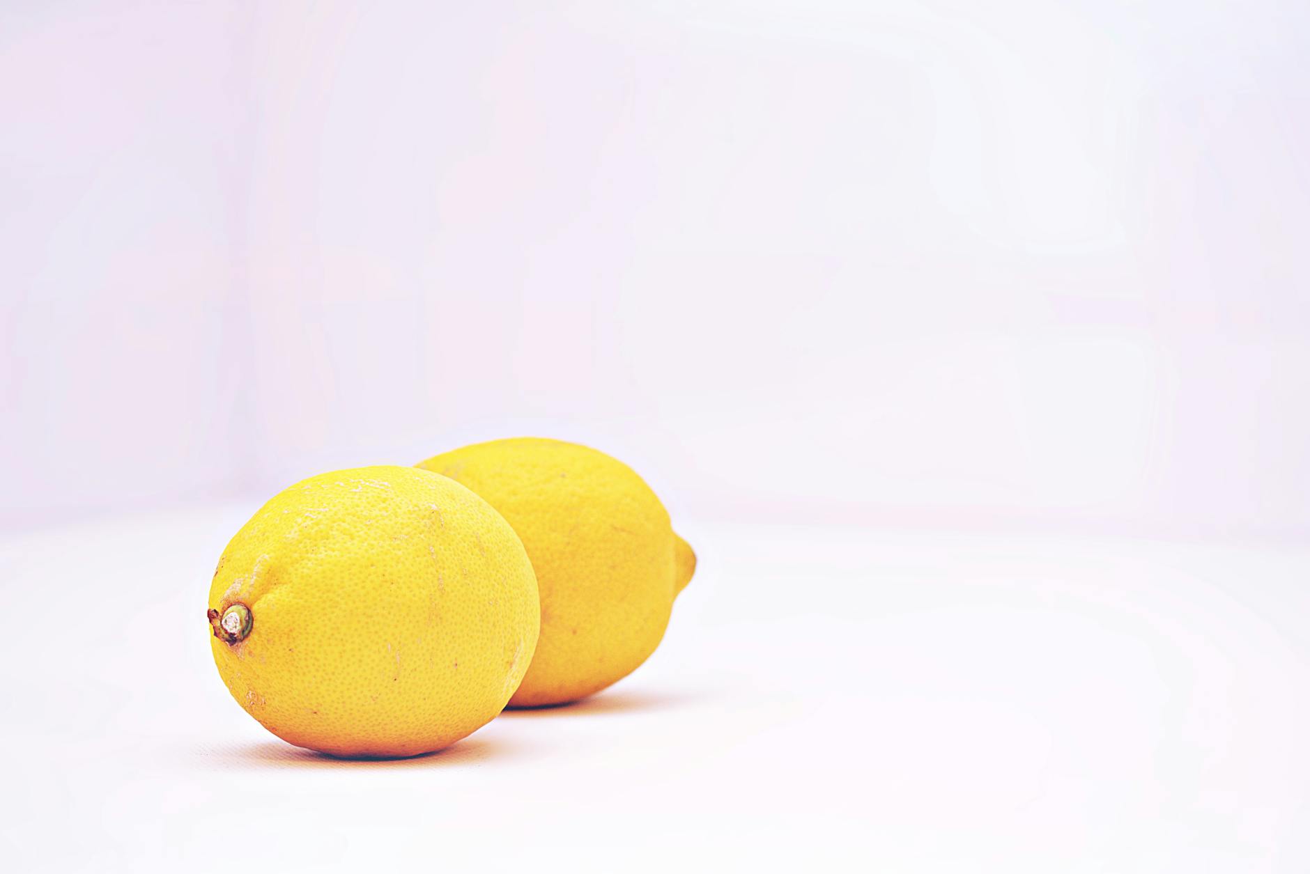 Two vibrant lemons against a white background, symbolizing freshness and the beginning of something new