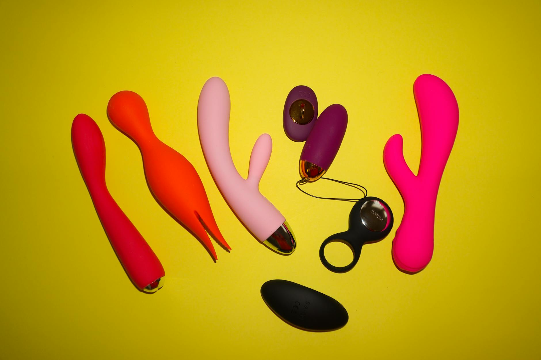 Colorful clitoral vibrators arranged on a bright background, symbolizing pleasure and intimacy